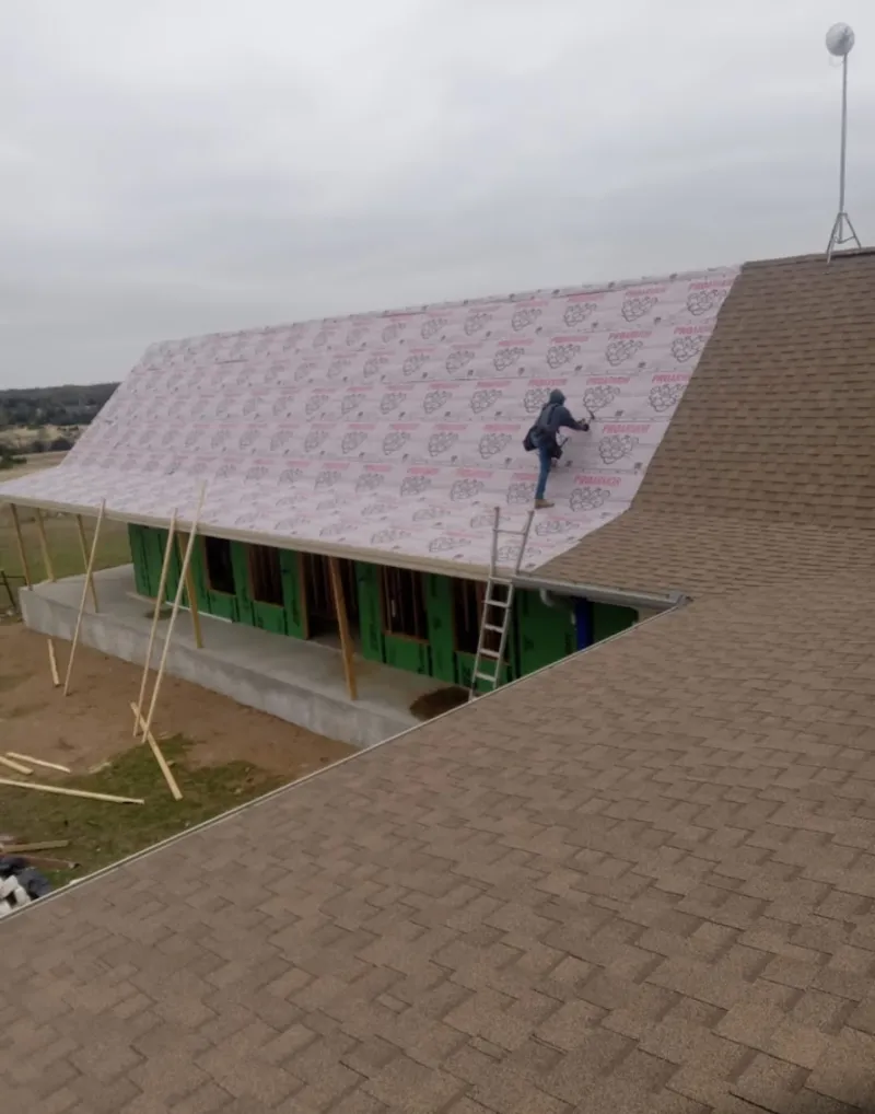 Worker preparing underlayment for a metal roof installation in Canal Fulton